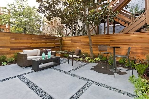 Contemporary courtyard with modern paving, wood screening and outdoor seating