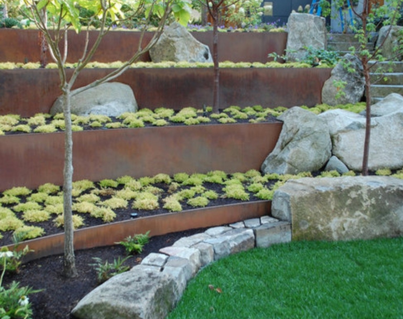 Corten steel terraced garden walls with stone and planting