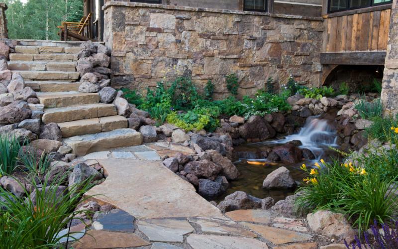 Naturalistic stream and waterfall beside stone garden steps